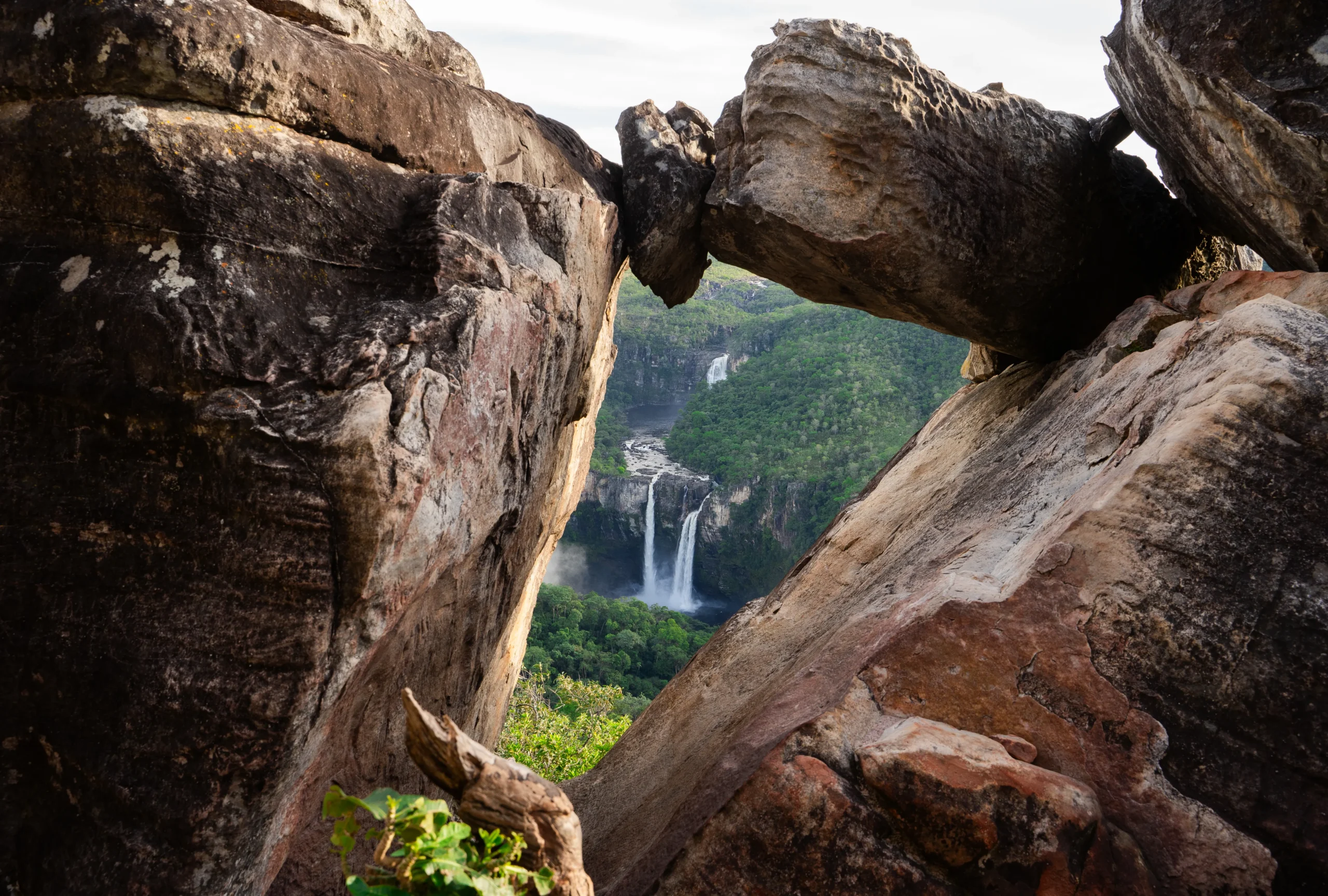 Cachoeira cercada por pedras rochosas na Chapada dos Veadeiros, vista entre formações naturais